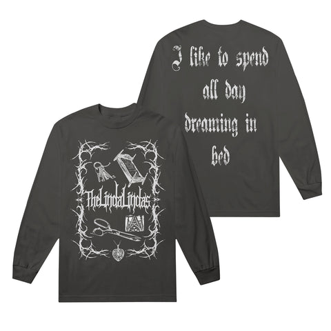 A black heavyweight unisex long sleeve by The Linda Lindas with gothic white graphics. Front reads "The Great Indoors" among home items; back says "I like to spend all day dreaming in bed" in stylized font.