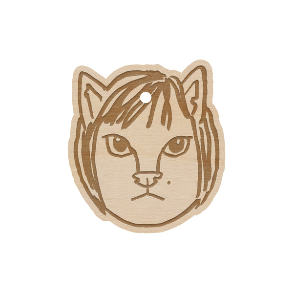 wooden ornament on a white background of a cat head member of the linda lindas