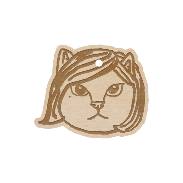 wooden ornament on a white background of a cat head member of the linda lindas