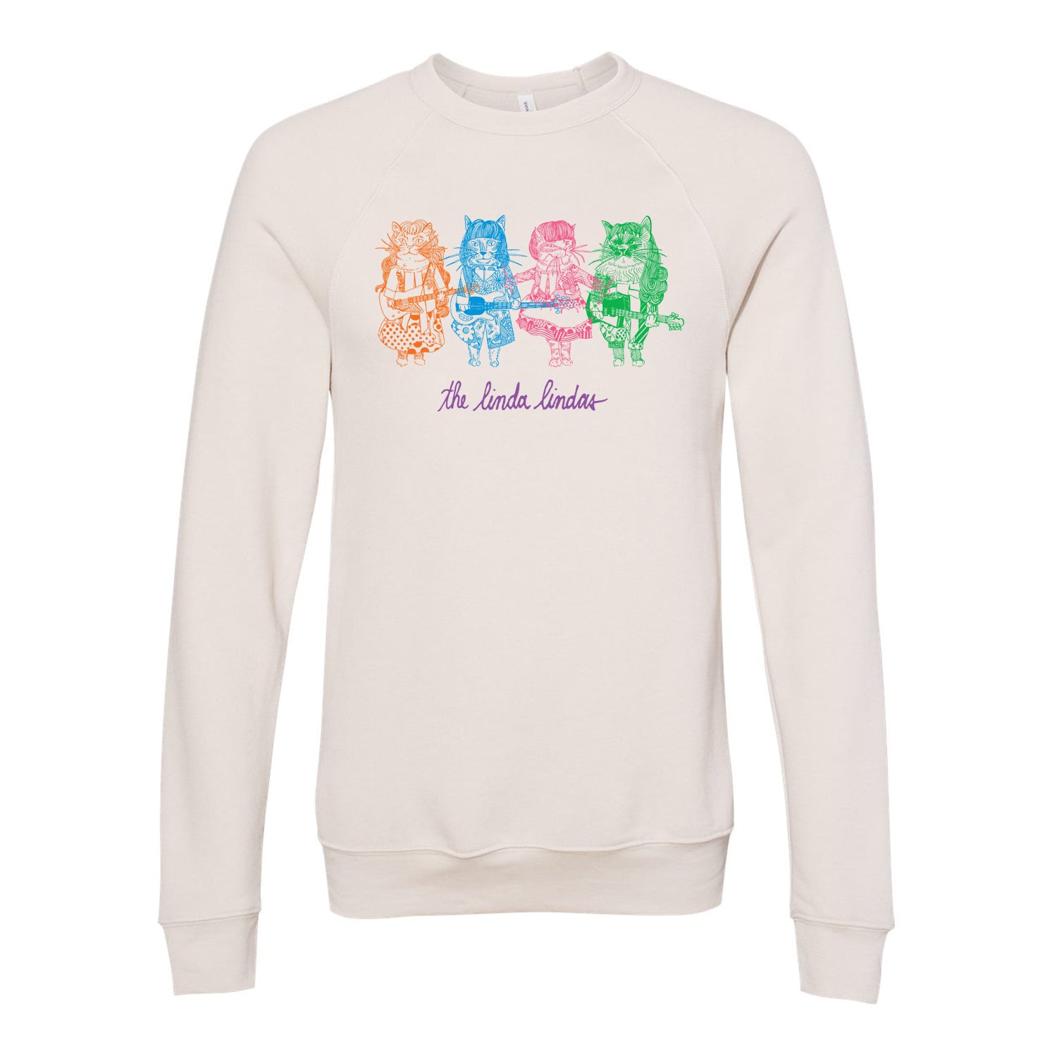 Image of a white longsleeve shirt against a white background. The center of the shirt features a graphic of four colorful cats holding instruments. One is orange, one is blue, one pink, and the other green. Below that in purple cursive reads "the linda lindas".