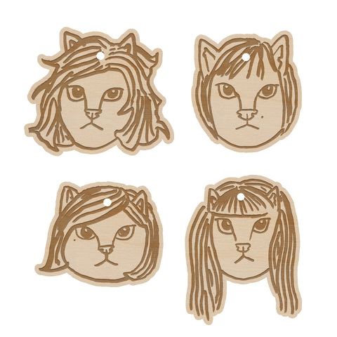 image of four wooden tree ornaments on a white background. each ornament is of the members of the linda lindas as cats